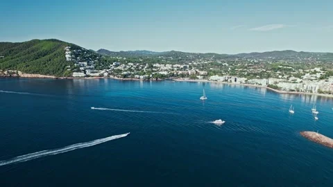 Ships floating by Santa Eulària des Riu coastal Town on a sunny day in Ibiza. Stock Footage 203829053