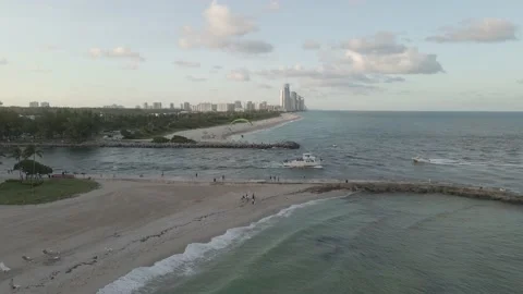 Ships motoring below, paramotor flies over Miami beach channel inlet 動画素材 167984115