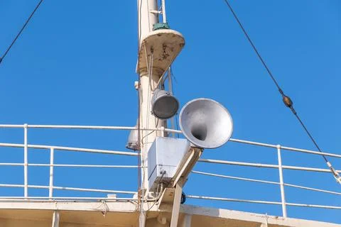 A ship's upper deck featuring metal structures such as a large loudspeaker, l Stock Photos