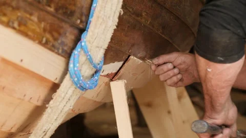 Shipwright fastening scarfed plank using copper nails Stock Footage 345725067