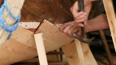 Shipwright securing plank hammering copper nails Stock Footage 345725056