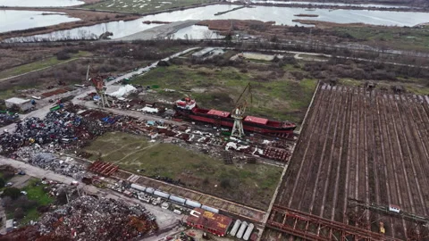 Shipyard scene shows workers repairing vessels near a river during the day with Stock Footage 336536101