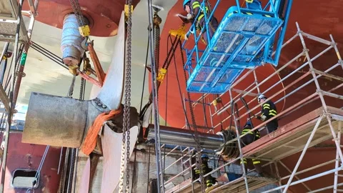 Shipyard Workers Repairing Large Vessel Propeller and Shaft System Stock Footage 329063433