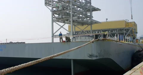 Shipyard workers work on the deck of a ship being repaired. Video stock 166388059