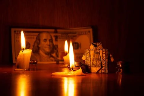 A shirt with a dollar bill and a stack of coins stand on a wooden cabinet a.. Stock Photos