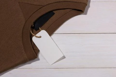 Shirt price tag. Rectangular tag is attached to a sweater Stock Photos