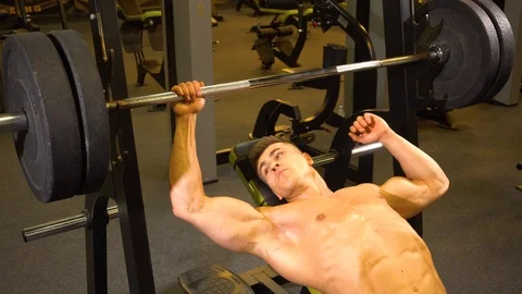 Shirtless athlete exercising with barbell Stock Footage 98990891