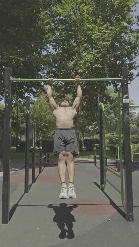 Shirtless athletic man with a defined physique performing pull-ups Video stock 326683591