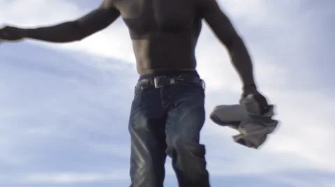 Shirtless black guy on a mountain peek, close up to his shoes Stock Footage 67532015