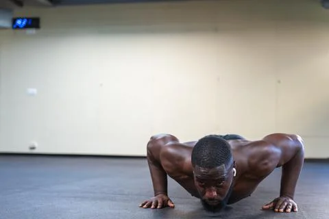 Shirtless black man doing push-ups at the gym Stock Photos