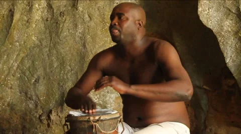 Shirtless Black man plays drum in cave in Cuba Stock Footage 45521543