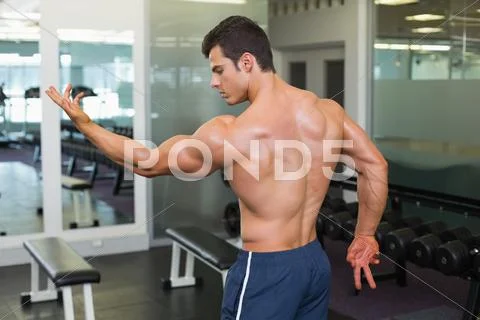Shirtless bodybuilder posing in gym Stock Photos