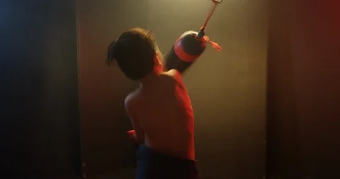Shirtless boy hitting the punching bag in gym Stock Footage 112078599