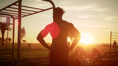Shirtless buffed man looking at other people in the park who are working out Stock Footage 279298919
