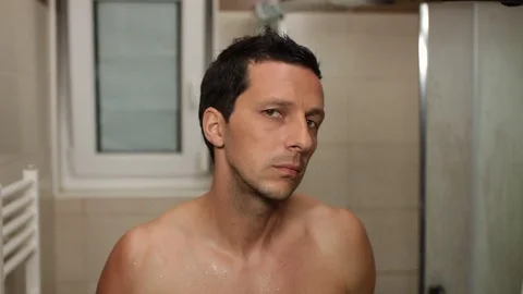 Shirtless man checking himself in the mirror. High definition video. Video stock 79496696