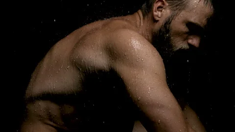 Shirtless Man Crouched Down as Rain Pouring Over His Muscular Body Stock Footage 270317165