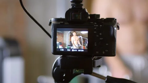 Shirtless Man Doing Dips on Parallel Bars and Talking on Camera Stock Footage 107602555