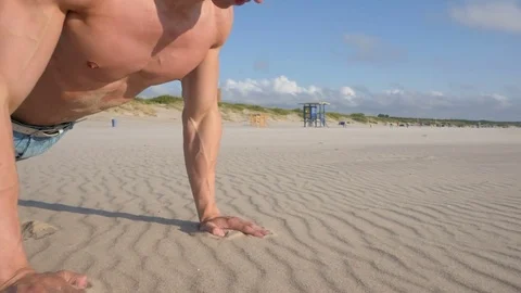 Shirtless man doing pull ups at the beach close up Stock Footage 84042031
