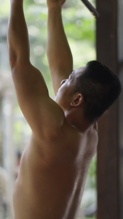 Shirtless man doing pullups in a park Stock Footage 264774767