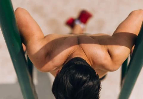 Shirtless man doing triceps dips on parallel bars Stock Photos