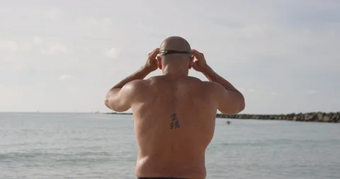 Shirtless man standing on the beach Stock Footage 116377065