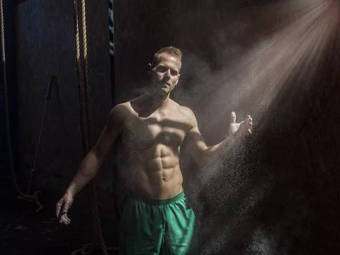 Shirtless man using chalk or magnesium powder in gym Stock Photos