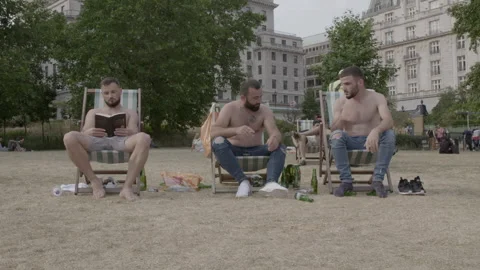Shirtless Men Relaxing and Drinking Beer in Deckchairs Stock Footage 344616811