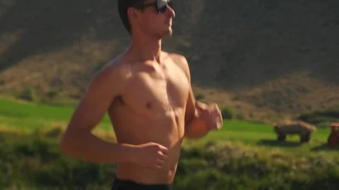 Shirtless runner races on a scenic Stock Video Pond5