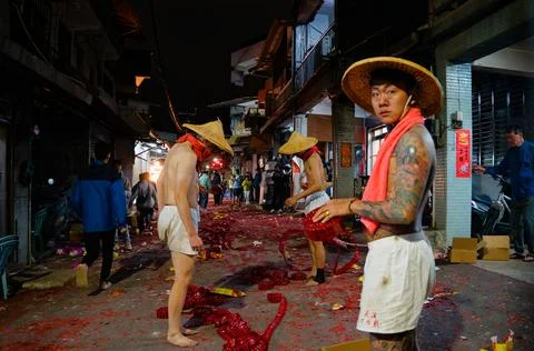Shirtless Workers Lay Firecracker Strings for Shezidao Earth God Festival Fotos Stock