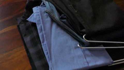Shirts and jeans on the table Stock Footage 128201654