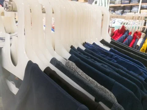 Shirts are displayed in an array using hangers inside a textile showroom. Foto stock