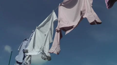 Shirts washing line blowing wind breeze blue sky clouds Stock Footage 48971923