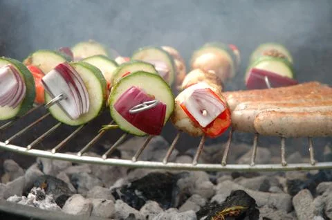 Shish-kebab and sausages cooking on barbecue Stock Photos