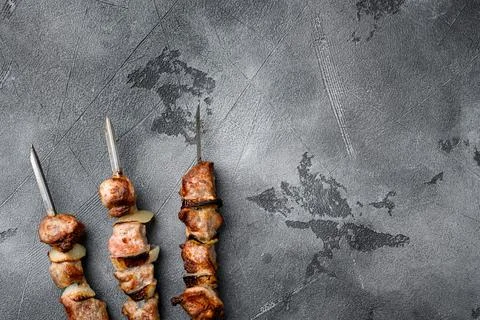 Shish kebab BBQ meat with onions and tomatoes, on gray stone table background Stock Photos
