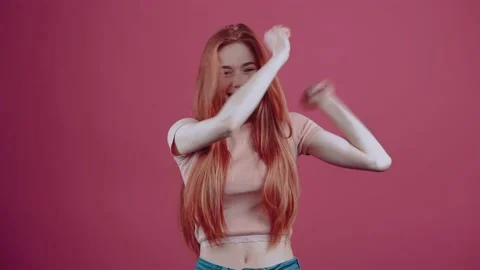 Shocked, 20-year-old redhead, in a pink casual T-shirt, isolated on a pink Stock Footage 150409434