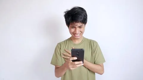 Shocked asian man looking at screen on smartphone 写真素材