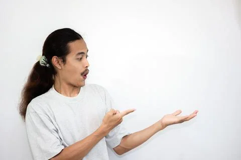 The shocked Asian man stood up while serving something beside him. Stock Photos