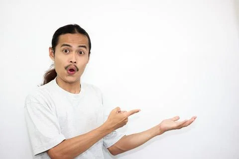 The shocked Asian man stood up while serving something beside him. Stock Photos