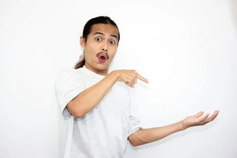 The shocked Asian man stood up while serving something beside him. Stock Photos