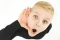 The shocked boy hold his hand near ear. View from above Photo