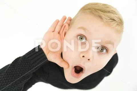 The shocked boy hold his hand near ear. View from above Stock Photos