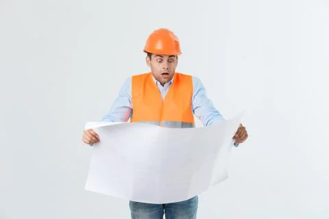 Shocked builder construction worker is holding in hand a plan draft document Stock Photos