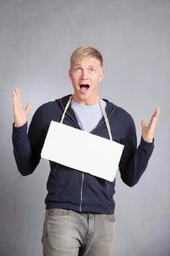 Shocked concerned man showing empty signboard. Stock Photos
