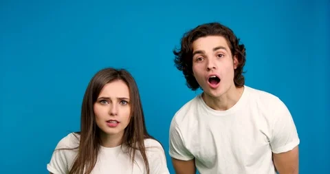 Shocked couple looking at camera, giving high five to each other and showing yes Stock Footage 123968076