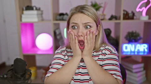 Shocked expression on face of young blonde woman streamer, afraid and amaze.. Stock Footage 263851341