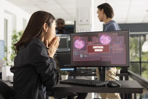 Shocked female programmer facing computer crash at work 库存照片