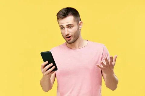 Shocked funny millennial man using mobile phone Stock Photos