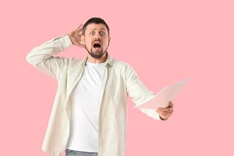 Shocked male actor with film script on pink background Stock Photos