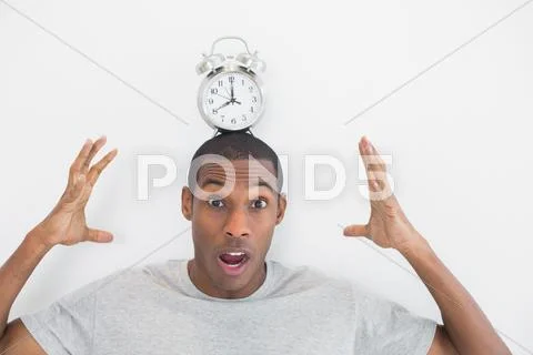 Shocked man with an alarm clock on top of his head Stock Photos