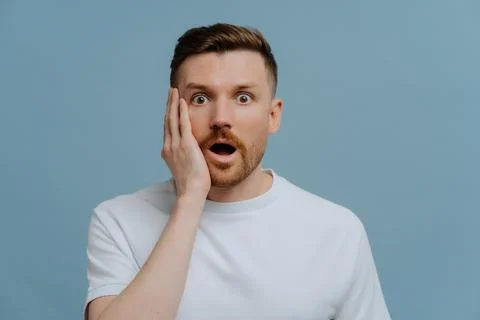 Shocked man looking at camera with surprised face expression Stock Photos